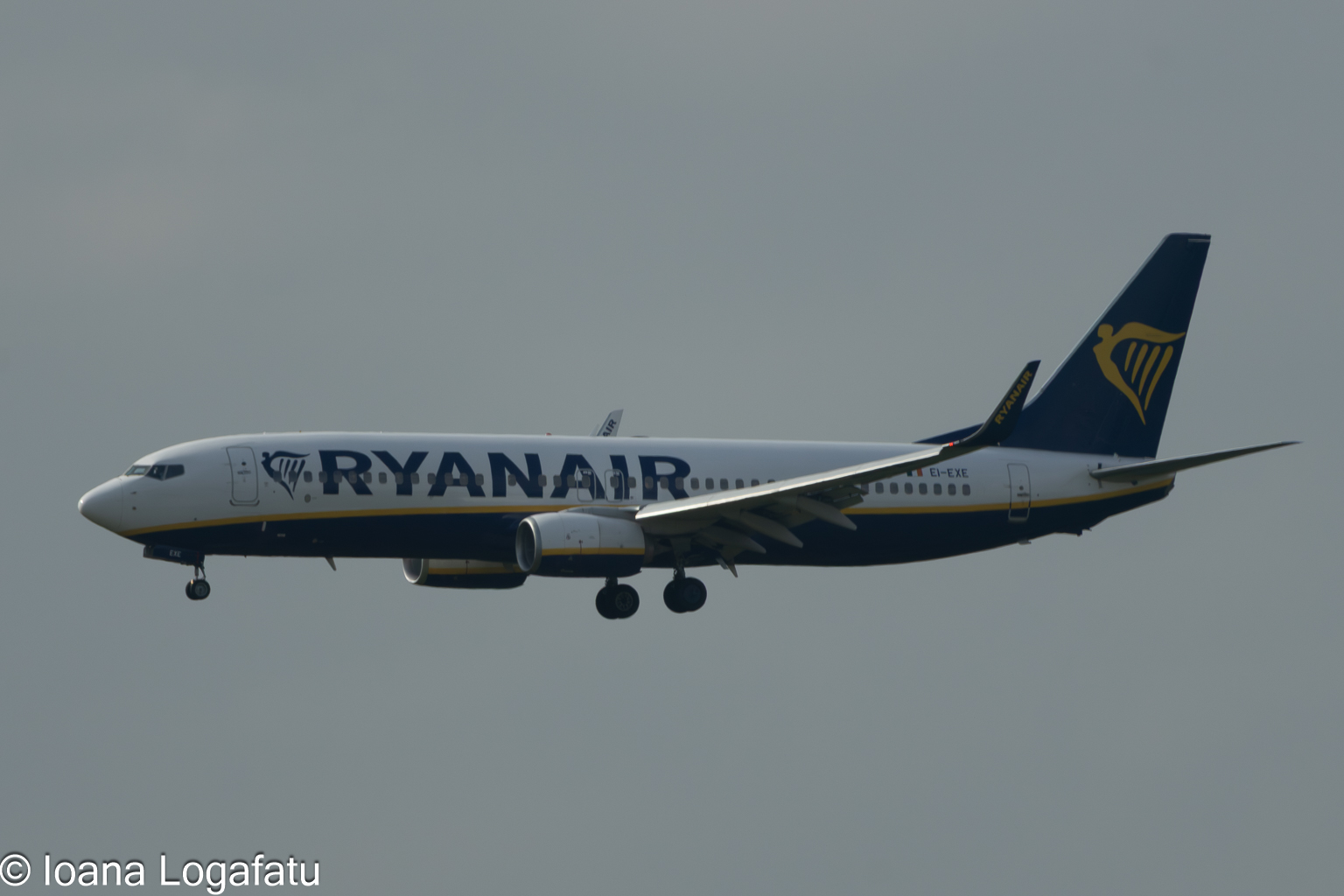Airplane soaring through a cloudy sky at sunset